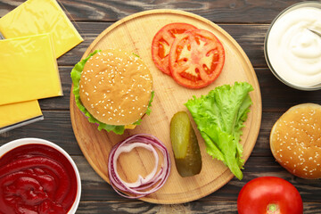Homemade burger ingredients arranged on wooden background