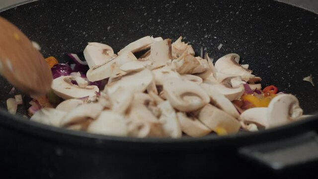 Motion controlled slow motion shot of mushrooms in a cooking pan