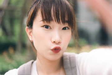 Portrait of young cute asian teenager student woman take a selfie photo by mobile phone