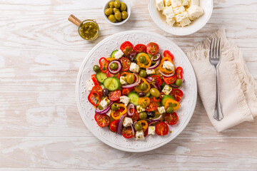 Greek salad of fresh cucumber, tomato, sweet pepper, red onion, feta cheese and olives with olive oil dressing