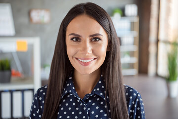 Portrait of young attractive smiling cheerful good mood positive businesswoman in dotted blouse and...