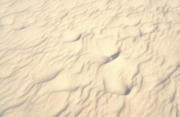 Light beach sand as a travel background with texture.