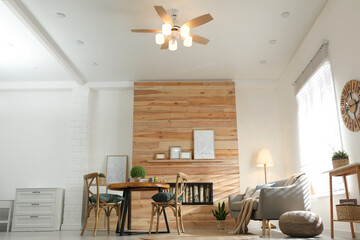Stylish living room interior with modern ceiling fan, low angle view