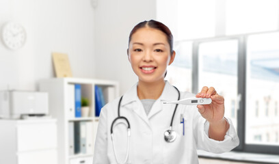 medicine, profession and healthcare concept - happy smiling asian female doctor with stethoscope and thermometer over medical office at hospital on background