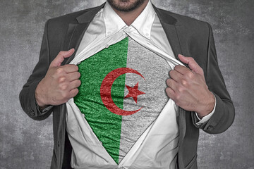 Business man rips open his shirt to show t-shirt with flag of Algeria