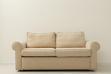 Comfortable sofa near beige wall in living room interior