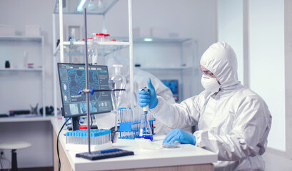 Researcher scientist working with micropipette in big scientific lab. Chemist in modern laboratory...