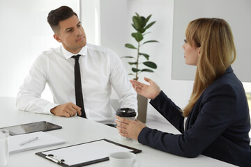 Office employees talking at table during meeting