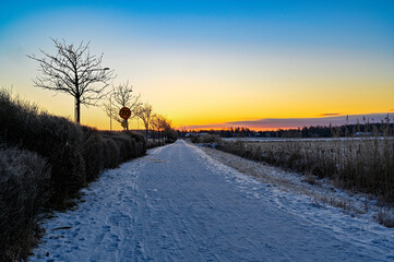 sunrise over cycle path covered in snow