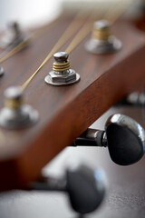 Fototapeta na wymiar music and musical instruments concept - close up of acoustic guitar head with pegs