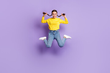 Fototapeta na wymiar Full size portrait of cheerful lady jumping hands hold playing with tails isolated on purple color background