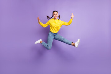 Fototapeta na wymiar Photo of sweet charming young woman braids wear yellow pullover jumping high isolated purple color background