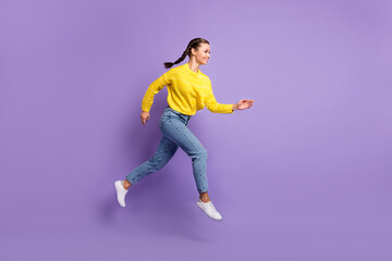 Fototapeta na wymiar Photo of shiny purposeful young woman braids wear yellow pullover jumping running isolated purple color background