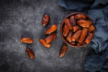 Dried date fruit in bowl on wooden background. Delicious dates fruit. Top view