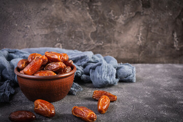 Dried date fruit in bowl on wooden background. Delicious dates fruit