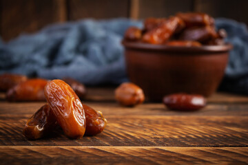 Dried date fruit in bowl on wooden background. Delicious dates fruit