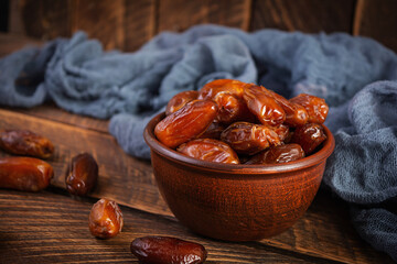 Dried date fruit in bowl on wooden background. Delicious dates fruit
