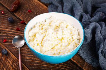 Cottage cheese with honey and berries on wooden background. Light vegetarian breakfast.
