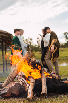 A group of friends enjoying an afternoon in the countryside - A group of young friends happily relaxing and enjoying a campfire.
