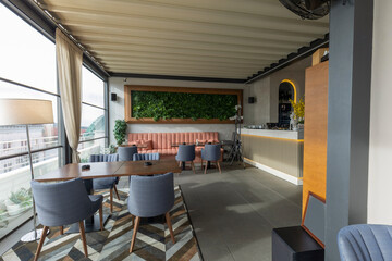 Interior of an empty restaurant with a view and a grass wall decoration