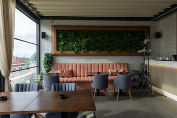 Interior of an empty restaurant with a view and a grass wall decoration