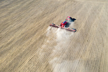 A farmer in a tractor prepares land with a sowing cultivator as part of pre-sowing work at the...