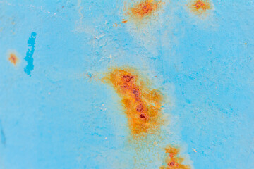 A blue metal wall with spots and streaks of rust.