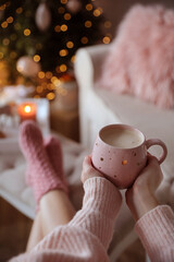 Woman holding cup of cocoa at home, closeup. Christmas mood