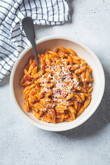 Gnocchetti sardi pasta in tomato sauce with cheese, gray background. Italian pasta concept