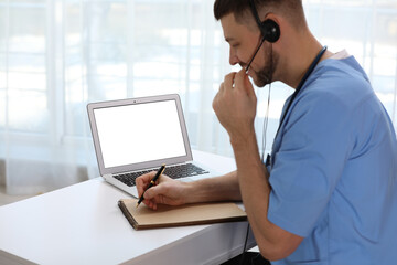 Doctor with headset consulting patient online at desk in clinic, space for text. Health service hotline