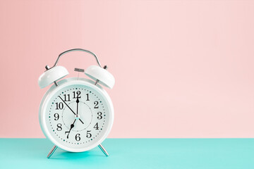 Vintage alarm clock on a pink green backdrop with copy space