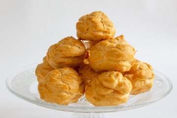 Eclairs on glass plate on a whight background. eclairs with cream.