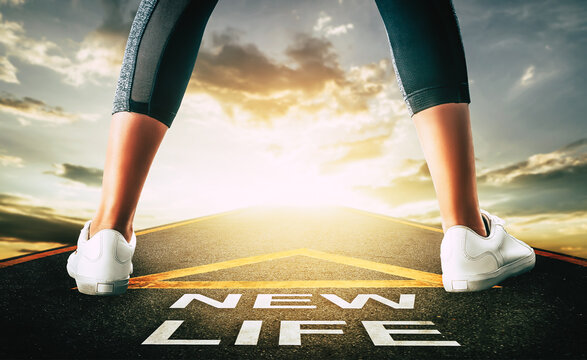 Woman standing on New life road leading to golden sky for New begining concept.