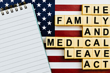 topview photo on FMLA (the family medical leave act) theme.  photo of open notepad with blank space, on a background of United States flag