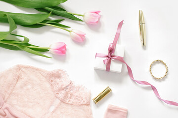 Obraz na płótnie Canvas A bouquet of pink tulips, a gift box with a pink bow, a blouse and cosmetics. The concept of Valentine's Day, Mother's Day, Birthday and spring for the blogger