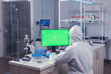 Medica staff using computer with green mok up in scientific laboratory. Team of microbiologists doing vaccine research writing on device with chroma key, isolated, mockup display.
