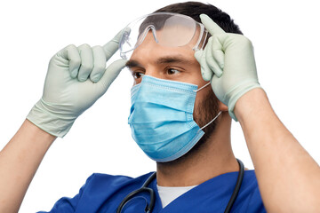 healthcare, profession and medicine concept - doctor or male nurse in blue uniform, face protective...