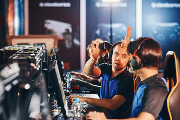 We are winning. Two happy male cyber sport gamers giving high five to each other, celebrating success while participating as one team in eSports tournament