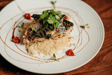Grilled mackerel and couscous on a white plate