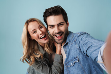 Young excited couple hugging while taking selfie photo