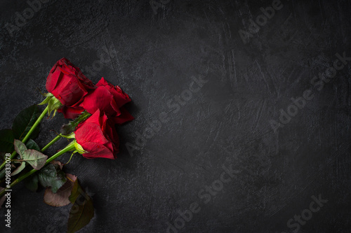 Red roses on a black background top view. Fresh, bright bouquet with drops of dew. Happy Valentine's Day, Happy Mother's Day. The concept of a birthday, Anniversary, wedding. Isolated copy space