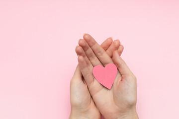 Young woman holding red heart valentines cards on pink background, top view.