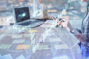 Double exposure of woman hands working on computer and forex graph hologram drawing. Financial analysis concept.