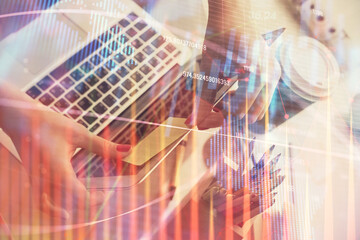 Double exposure of businesswoman hands typing on computer and financial graph hologram drawing. Stock market analysis concept.