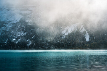 mystic atmosphere on early winter with first snow at mountain lake Oeschinensee