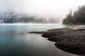 mystic atmosphere on early winter with first snow at mountain lake Oeschinensee