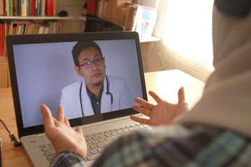 Online medical healthcare services, muslim woman doing video call with male doctor, telehealth, telemedicine consultation