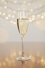 Glass of wine with bokeh background close up. Flat lay. New Year, Christmas mood. Greeting card. Party and holiday celebration concept.