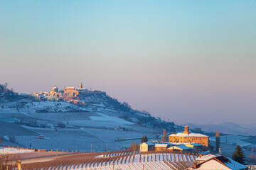 Italy Piedmont: wine yards unique landscape winter, La Morra village perched on hill top, sunset dramatic sky background, italian grapes heritage panoramic view