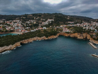 Fototapeta na wymiar Aerial view over Votsi beach (Paralia Votsi) and the picturesque port with traditional wooden fishing boats in Alonnisos island during Winter period in Sporades, Greece